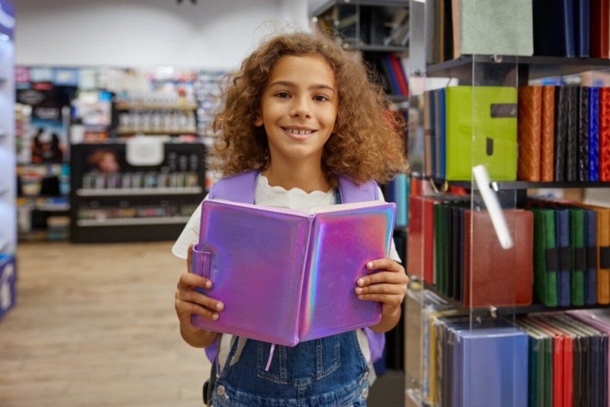 Fetita cu un jurnal in mana intr-o librarie Fetita cu un jurnal in mana intr-o librarie
